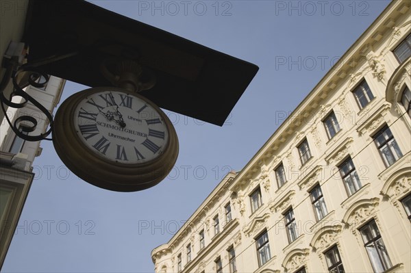 Vienna, Austria. Clock and watchmaker sign with part seen exterior facade of Empire era building behind. Austria Austrian Republic Vienna Viennese Wien Europe European City Capital Architecture Clock Facade Exterior Watchmaker Sign Destination Destinations Osterreich Signs Display Posted Signage Viena Western Europe