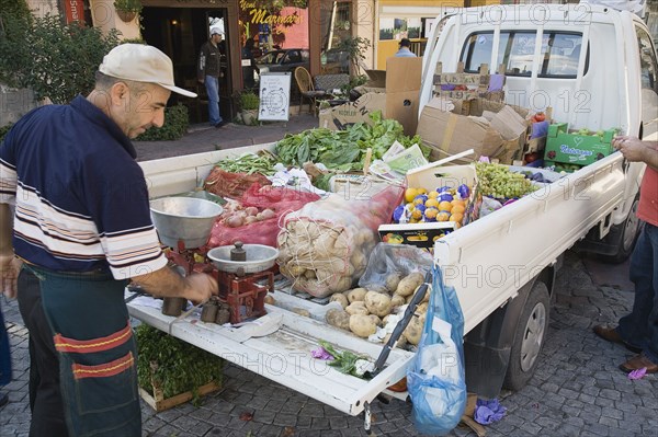 Istanbul, Turkey. Sultanahmet. Fresh produce arrives by truck for local shoppers with set of scales on the open tail gate and back filled with sacks of potatoes boxes of oranges apples grapes and lettuce. Turkey Turkish Istanbul Constantinople Stamboul Stambul City Europe European Asia Asian East West Urban Destination Travel Tourism Sultanahmet Market Stall Stall Vegetable Vegetables Food Produce Vendor Selling Truck Van Scales Destination Destinations Lorry Middle East South Eastern Europe Turkiye Western Asia