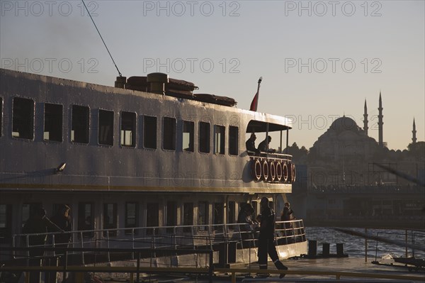 Istanbul, Turkey. Sultanahmet. Bosphorous passenger ferry at sunset with Hagia Sophia behind. Turkey Turkish Istanbul Constantinople Stamboul Stambul City Europe European Asia Asian East West Urban Destination Travel Tourism Sultanahmet Bosphorous Passenger Passengers Ferry Boat Ship Transport Water Sea Commute Commuters Hagia Sophie Mosque Destination Destinations Middle East Religion Religious South Eastern Europe Sundown Atmospheric Turkiye Water Western Asia