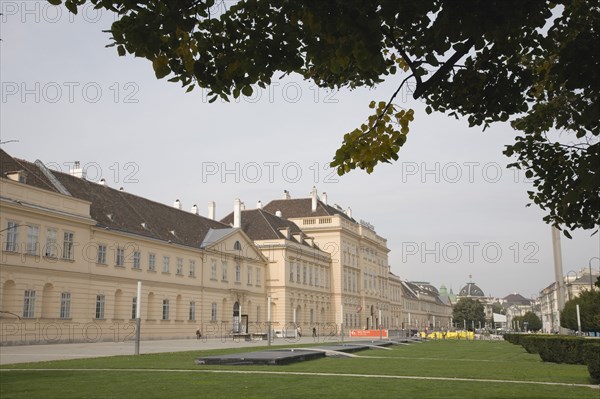 Vienna, Austria. Neubau District. MuseumsQuartier or the Museum Quarter the former Imperial Stalls which were converted into a museum complex in the 1990s. Exterior and formal lawns part framed by tree branches. It houses the Museum of Modern Art or MUMOK the Leopold Museum the Museum of Architecture or Az W and contemporary exhibition spaces. Austria Austrian Republic Vienna Viennese Wien Europe European City Capital Neubau District Museumsquartier Museum Quarter Imperial Stalls Mumok Modern Art Leoplod Destination Destinations Osterreich Viena Western Europe