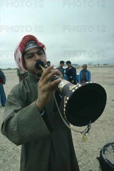 Music, Bahrain. Man playing traditional horn instrument. Bahraini Classic Classical Historical Male Men Guy Middle East Older One individual Solo Lone Solitary