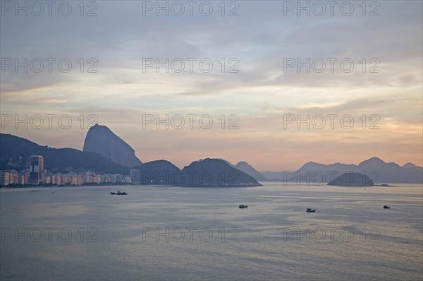 Rio de Janeiro, Brazil. Copacabana and Sugarloaf Mountain at dawn with fishing boats in the bay dreamy sky and sea. Brazil Brasil Brazilian Brasilian South America Latin Latino American City Travel Destination Urban Vacation Copacabana Beach Sugarloaf Sugar Loaf Mountain Blue Destination Destinations Latin America Sand Sandy Beaches Tourism Seaside Shore Tourist Tourists Vacation Scenic South America Southern Water