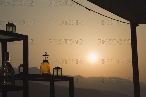 Samos, Northern Aegean, Greece. Vathy. Sun setting behind open air bar with the Ampelos massif beyond. Greece Greek Europe European Vacation Holiday Holidays Travel Destination Tourism Ellas Hellenic Aegean Aegean Samos Island Sea Water Ampelos Massif Bar Drinks Bottles Sun Silhouette Silhouette Silhouetted Destination Destinations Ellada Scenic Solid Outline Shade Silhouette Solid Outline Shade Silhouetted Southern Europe Sundown Atmospheric Water