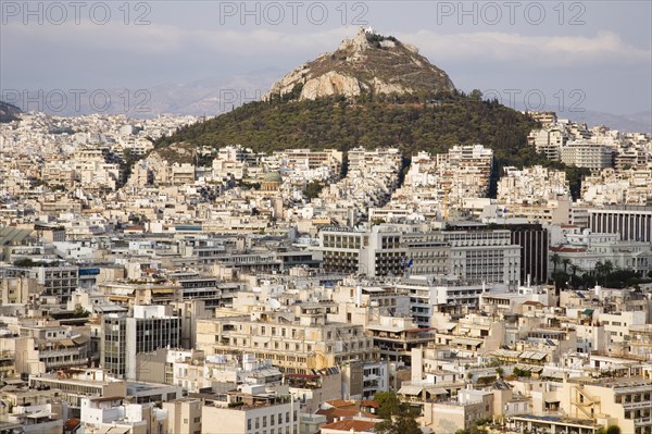 Athens, Attica, Greece. Mount Lycabettus rising in central Athens with densely populated city below. Greece Greek Europe European Vacation Holiday Holidays Travel Destination Tourism Ellas Hellenic Attica Athens City View Cityscape Aerial Elevated Houses Housing Mount Lycabettus Atenas Athenes Destination Destinations Ellada Southern Europe