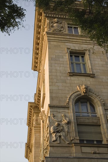 Budapest, Pest County, Hungary. Part view of exterior facade of building with bas relief carving of metal workers. Hungary Hungarian Europe European East Eastern Buda Pest Budapest City Architecture Detail Details Facade Building Destination Destinations Eastern Europe