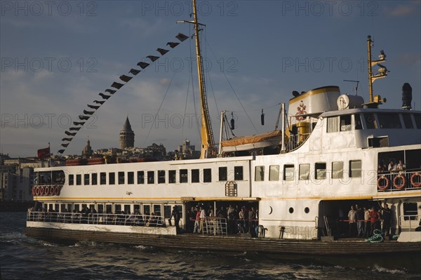 Istanbul, Turkey. Sultanahmet. Crowded ferry flying Turkish flag on the Bosphorous with city behind. Since March 2006 Istanbuls traditional commuter ferries have been operated by Istanbul Sea Buses. Turkey Turkish Istanbul Constantinople Stamboul Stambul City Europe European Asia Asian East West Urban Sultanahmet Bosphorous Destination Travel Tourism Transport Water Ship Boat Ferry Commuter Cummuters Classic Classical Destination Destinations Historical Middle East Older South Eastern Europe Turkiye Water Western Asia