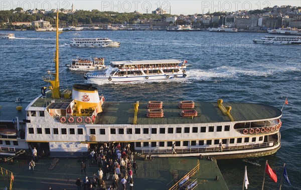 Istanbul, Turkey. Sultanahmet. People boarding Bosphorous passenger ferry at sunset with Hagia Sophia behind. Turkey Turkish Istanbul Constantinople Stamboul Stambul City Europe European Asia Asian East West Urban Destination Travel Tourism Sultanahmet Bosphorous Passenger Passengers Ferry Boat Ship Transport Water Sea Commute Commuters Hagia Sofia Mosque Destination Destinations Middle East South Eastern Europe Sundown Atmospheric Turkiye Water Western Asia