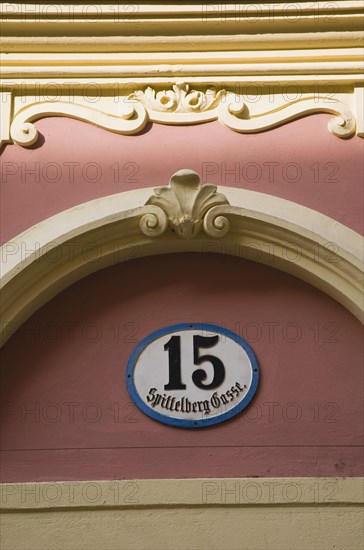 Vienna, Austria. Detail of pink and cream painted exterior facade with street number 15. Austria Austrian Republic Vienna Viennese Wien Europe European City Capital Architecture Building Facade Exterior Number Street Detail pinkl Cream Paint Painted Color Destination Destinations Osterreich Viena Western Europe