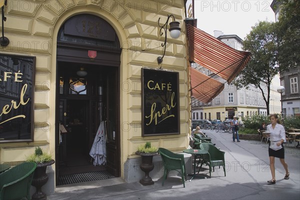 Vienna, Austria. Mariahilf District. Cafe Sperl the preferred cafe of Adolf Hitler. Exterior with waitress carrying coffee order. Austria Austrian Vienna Viennese Wien Mariahlf 6th District Cafe Sperl Hitler Waitress Entrance Coffee Exterior Europe European Work Urban City Table Tables Schanigarten Bar Bistro Destination Destinations History Historic Osterreich Restaurant Viena Western Europe