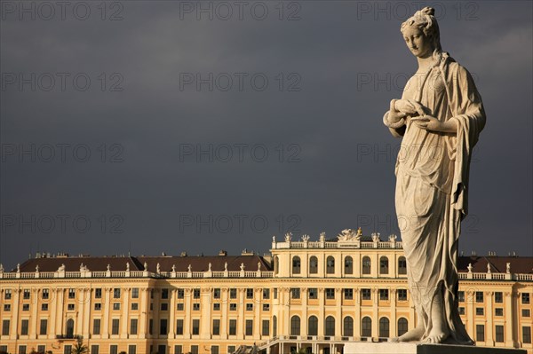 Vienna, Austria. Statue in the formal gardens of the Schonbrunn Palace. Austria Austrian Vienna Wien Viennese Republic Austro-Bavarian Wean Europe European City Capital Exterior Travel Destination SchonnBrunn Schonbrunn Schloss Palace Architecture Art Imperial Summer Residence UNESCO World Heritage Site Beautifu Spring. Formal Garden Gardens Statue Woman Female Figure Blue Clouds Cloud Sky Destination Destinations Female Women Girl Lady Garden Plants Flora Gardens Plants Gray History Historic Osterreich Viena Western Europe