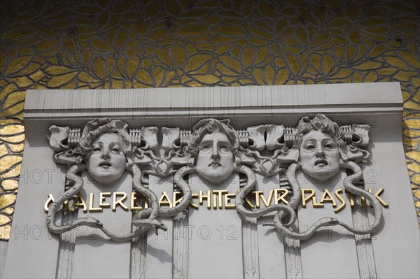 Vienna, Austria. Secession Building designed by the architect Joseph Maria Olbrich in 1897 as the manifesto of the Viennese Secession Movement. Detail of white and gold exterior facade depicting the heads of three gorgons representing architecture sculpture and painting. Austria Austrian Republic Vienna Viennese Wien Europe European City Capital Architetcure Art Building Facade Seccesion Gorgons Carved 3 Destination Destinations Osterreich Viena Western Europe