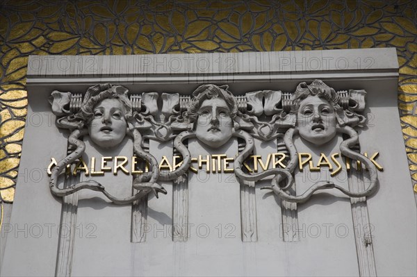 Vienna, Austria. Secession Building designed by the architect Joseph Maria Olbrich in 1897 as the manifesto of the Viennese Secession Movement. Detail of white and gold exterior facade depicting the heads of three gorgons representing architecture sculpture and painting. Austria Austrian Republic Vienna Viennese Wien Europe European City Capital Architetcure Art Building Facade Seccesion Gorgons Carved 3 Destination Destinations Osterreich Viena Western Europe