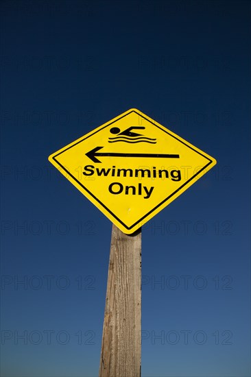 Shoreham-by-Sea, West Sussex, England. Sign indicating stretch of beach suitable for safe swimming. Sign Signs Information Warn Warning Indicate Indicating Safe Safety Yellow Blue Sky Swim Swimming Swimmer Swimmers Show Showing Point Pointing Arrow Post Only