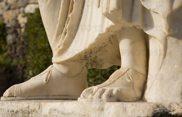 Selcuk, Izmir Province, Turkey. Ephesus. Detail of feet of marble statue in ancient city of Ephesus on the Aegean sea coast. Turkey Turkish Eurasia Eurasian Europe Asia Turkiye Izmir Province Selcuk Ephesus Ruin Ruins Roman Column Columns Facde Ancient Architecture Masonry Rock Stone Statue Detail Foot Feet Destination Destinations European History Historic Middle East South Eastern Europe Water Western Asia