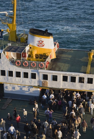 Istanbul, Turkey. Sultanahmet Bosphorous passenger ferry at sunset with people gathered to board. Asian Destination Destinations European Middle East South Eastern Europe Sundown Atmospheric Turkish Turkiye Western Asia