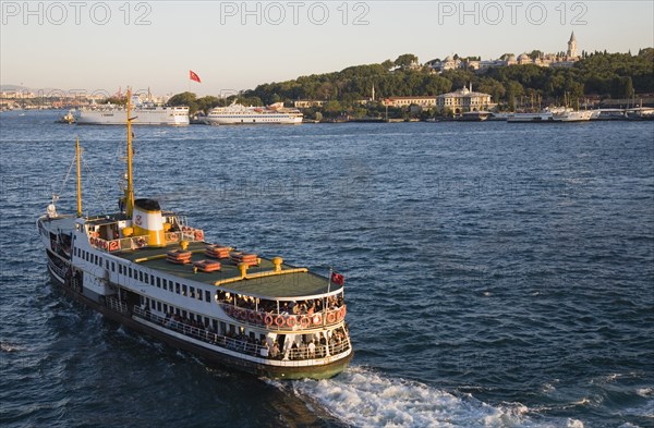 Istanbul, Turkey. Sultanahmet Crowded Bosphorous passenger ferry at sunset. Turkey Turkish Istanbul Constantinople Stamboul Stambul City Europe European Asia Asian East West Urban Destination Travel Tourism Sultanahmet Bosphorous Passenger Passengers Ferry Boat Ship Transport Water Sea Commute Commuters Destination Destinations Middle East South Eastern Europe Sundown Atmospheric Turkiye Water Western Asia