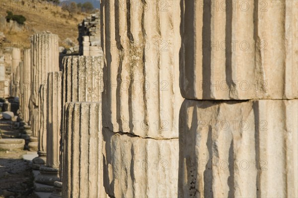 Selcuk, Izmir Province, Turkey. Ephesus. Line of broken columns in ancient city of Ephesus on the Aegean sea coast. Turkey Turkish Eurasia Eurasian Europe Asia Turkiye Izmir Province Selcuk Ephesus Ruin Ruins Roman Column Columns Facde Ancient Architecture Masonry Rock Stone Destination Destinations European History Historic Middle East South Eastern Europe Water Western Asia