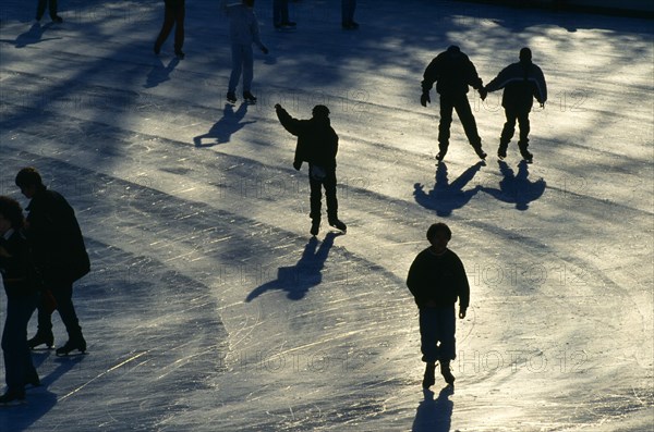 New York, New York, USA. Central Park ice skaters casting long shadows Kids North America United States of America
