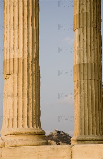 Athens, Attica, Greece. Part view of Acropolis and Parthenon columns framing distant view towards Lycabetus Hill. Greece Greek Europe European Vacation Holiday Holidays Travel Destination Tourism Ellas Hellenic Attica Athens Acropolis Ruin Ruins Column Columns Parthenon Lycabettus Mount Hill Atenas Athenes Destination Destinations Ellada History Historic Southern Europe