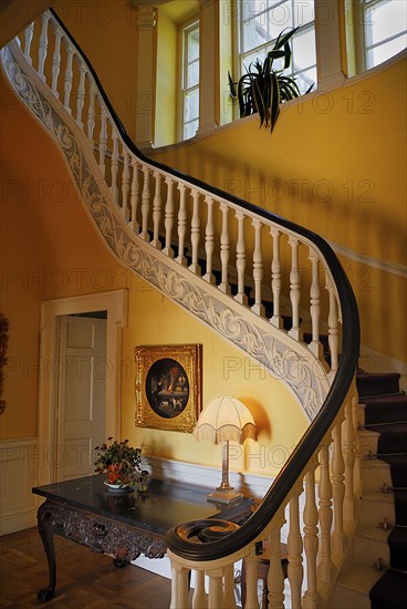 Belvedere House, County Westmeath, Ireland. House interior showing ornate staircase. Ireland Irish Eire Erin Europe European County West Meath Westmeath Belvedere House Architecture Interior Hall Hallway Stairs Staircase Table Lamp Painting Artwork Color Destination Destinations History Historic Northern Europe Poblacht na hEireann Republic Colour