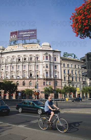 Budapest, Pest County, Hungary. Cyclist and traffic at the rail terminus Budapest Nyugati palyaudvar. Hungary Hungarian Europe European East Eastern Buda Pest Budapest City Road Street Traffic Busy Cars Autos Automobiles Cyclist Bike Bicycle Architecture Blue Sky Urban Destination Destinations Eastern Europe