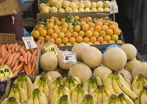 Athens, Attica, Greece. Central Market. Fruit and vegetable summer produce for sale on grocers stall including melons bananas and carrots. Atenas Athenes Destination Destinations Ellada European Greek Southern Europe