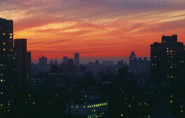 New York, New York State, USA. Upper East Side city skyline at dusk with red and purple sunset sky. Blue Citiscape Building Buildings Urban Architecture Nightfall Twilight Evenfall Crespuscle Crespuscule Gloam Gloaming North America Sundown Atmospheric United States of America