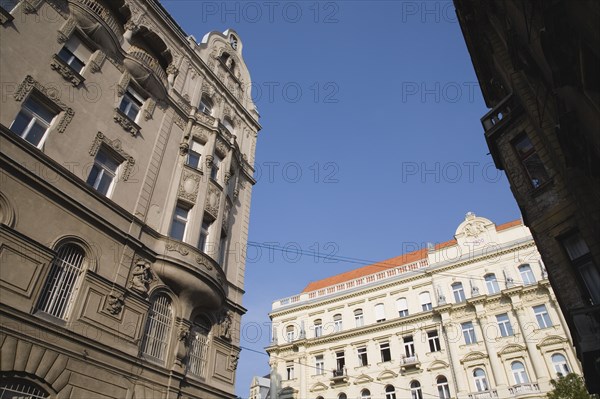 Budapest, Pest County, Hungary. Angled view of renovated building facades. Hungary Hungarian Europe European East Eastern Buda Pest Budapest City Architecture Facade Buildings Renovated Restored Blue Sky Destination Destinations Eastern Europe