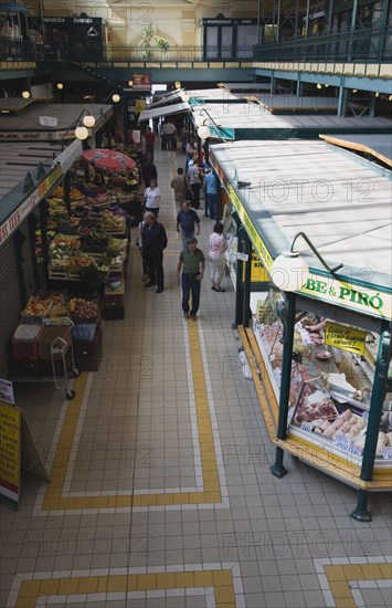 Budapest, Pest County, Hungary. Central aisle at Nagy Vasarcsarnok the Central Market. Hungary Hungarian Budapest Buda Pest Europe European City Nagy Vasarcsarnok Central Market Interior inside Stalls Shoppers Market markets Nagy Vasarcsarnok Nagy Vasarcsarnok Food Customers Destination Destinations Eastern Europe