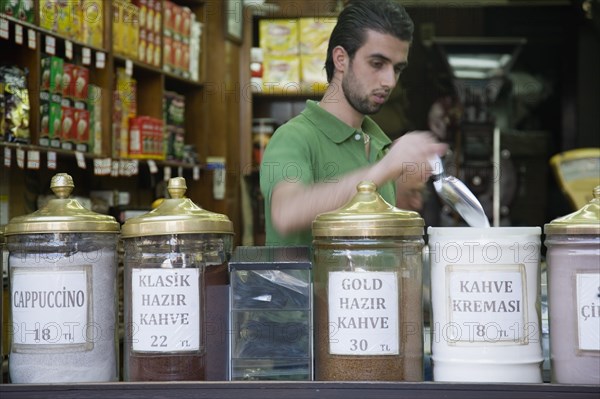 Istanbul, Turkey. Sultanahmet. Coffee or kahve shop and young male vendor in the The Spice Bazaar or Egyptian Bazaar one of the oldest bazaars in the city and the second largest covered shopping complex after the Grand Bazaar. Turkey Turkish Istanbul Constantinople Stamboul Stambul City Europe European Asia Asian East West Urban Destination Travel Tourism Sultanahmet Coffee Kahve Male Man Vendor Spice Bazaar Market Shop Store Stall Interior 1 Destination Destinations Immature Male Men Guy Middle East One individual Solo Lone Solitary Shops Shoppers Mall Retail Buy Buying Market Markets Single unitary South Eastern Europe Turkiye Western Asia