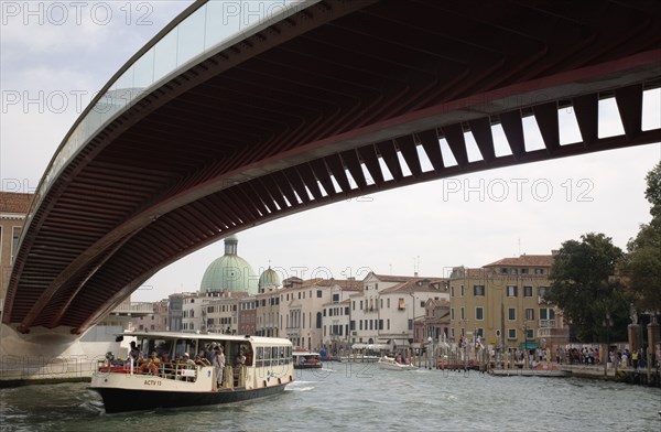 Venice, Veneto, Italy. Ponte di Calatrava Bridge Fourth bridge across the Grand Canal opened in September 2008 linking the train station and Piazzale by Spanish architect Santiago Calatrava. Passenger boat passing underneath Italy Italia Italian Venice Veneto Venezia Europe European City Grand Canal Fourth Bridge Ponte Di Calatrava Architecture Water Transport Ferry Commuters Tourists Blue Clouds Cloud Sky Destination Destinations Holidaymakers Southern Europe Tourism