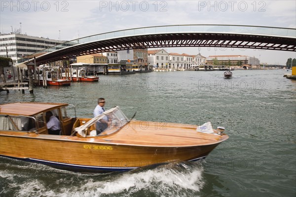 Venice, Veneto, Italy. Ponte di Calatrava Bridge Fourth bridge across the Grand Canal opened in September 2008 linking the train station and Piazzale by Spanish architect Santiago Calatrava. Passing water taxi in foreground. Italy Italia Italian Venice Veneto Venezia Europe European City Grand Canal Fourth Bridge Ponte Di Calatrava Architecture Water Transport Transport Commuters Tourists Boat Boats Destination Destinations Holidaymakers Southern Europe Tourism