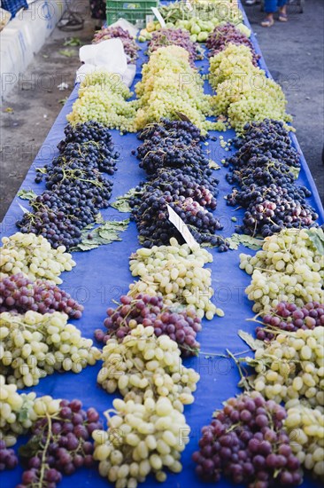 Kusadasi, Aydin Province, Turkey. Grapes for sale on street stall in weekly market stall. Azirince is the nearby wine producing region. Turkey Turkish Eurasia Eurasian Europe Asia Turkiye Aydin Province Kusadasi Market Markets Grapes Stall Display Destination Destinations European Middle East South Eastern Europe Vino Vin Alcohol Grape Winery Drink Western Asia