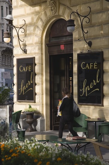 Vienna, Austria. Mariahilf District Cafe Sperl the preferred cafe of Adolf Hitler. Exterior with empty outside tables and woman passing entrance carrying bags. Established for over 120 years the Cafe Sperl offers billiards and forbids mobile phone use. Austria Asutrian Vienna Viennese Mariahlf 6th District Cafe Sperl Hitler Waitress Entrance Coffee Exterior Europe European Work Urban City Table Tables Schanigarten Austrian Bar Bistro Cell Cellular Destination Destinations Female Women Girl Lady History Historic One individual Solo Lone Solitary Osterreich Restaurant Viena Western Europe Wien