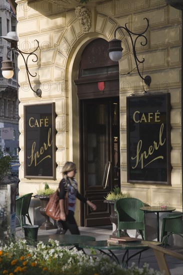 Vienna, Austria. Mariahilf District Cafe Sperl the preferred cafe of Adolf Hitler. Exterior with empty outside tables and woman walking past entrance. Established for over 120 years the cafe offers billiards and forbids mobile phones. Austria Asutrian Vienna Viennese Mariahlf 6th District Cafe Sperl Hitler Waitress Entrance Coffee Exterior Europe European Work Urban City Table Tables Schanigarten Austrian Bar Bistro Cell Cellular Destination Destinations Female Women Girl Lady History Historic One individual Solo Lone Solitary Osterreich Restaurant Viena Western Europe Wien