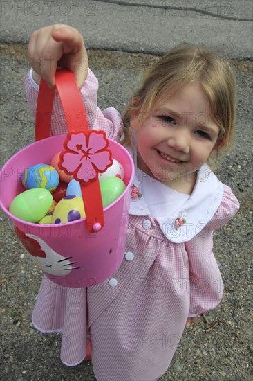 Young girl Sarah Bleau holding up basket of Easter eggs collected on Easter egg hunt in Keene New Hampshire. Festival Festivals Religion Religious Christian Christianity Easter Egg Hunt Hunting Young Girl Sarah Bleau MR Model Release Released Model Keene NH New Hampshire USA United States State America American Immature Kids New Hampshire Live Free or Die Granite State North America Northern One individual Solo Lone Solitary Religion Religious Christianity Christians United States of America