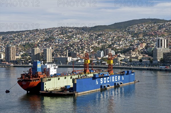 Valparaiso, Chile. Floating dry dock at the once again busy port now a UNESCO World Heritage city. Chile Chilean South America American Hispanic Santiago City Cityscape Urban Valparaiso Floating Dry Dock Transport Port Harbour Ship Boat Crane Cranes UNESCO Hertiage Site Water Sea Ocean Latin America Latino Paradise Valley South America Southern Valpo Water
