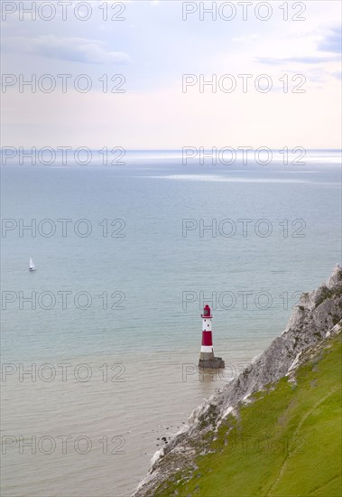 Eastbourne, East Sussex, England. Beachy Head view of the lighthouse at the base of the chalk cliffs. England English UK United Kingdom GB Great Britain Birtish East Sussex County Eastbourne Beachy Head Sea Coast Chalk Cliff Cliffs White Lighthouse Light House Boat Ship Transport Warning