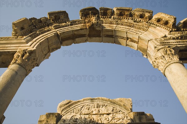 Selcuk, Izmir Province, Turkey. Ephesus. Detail of carved archway supporting columns and wall frieze in ancient ruined city of Ephesus on the Aegean sea coast. Turkey Turkish Eurasia Eurasian Europe Asia Turkiye Izmir Province Selcuk Ephesus Ruin Ruins Roman Column Columns Facde Ancient Architecture Masonry Rock Stone Arch Blue Destination Destinations European History Historic Middle East South Eastern Europe Water Western Asia