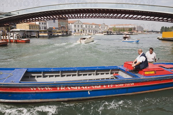 Venice, Veneto, Italy. Ponte di Calatrava Bridge Fourth bridge across the Grand Canal opened in September 2008 linking the train station and Piazzale by Spanish architect Santiago Calatrava. Red and blue painted working canal boat passing in foreground. Italy Italia Italian Venice Veneto Venezia Europe European City Grand Canal Fourth Bridge Transport Water Architecture Di Calatrava Ponte Bridge Fourth Canal Grand Boat Boats Barge Destination Destinations Southern Europe