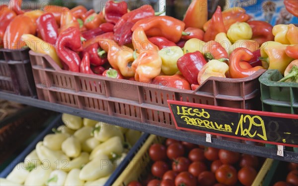 Budapest, Pest County, Hungary. Crate of red orange and yellow Capsicum annuum or Bell Chili peppers also known as paprika in reference to the spice produced in dried and ground form on stall with price label attached. Chilli Color Destination Destinations Eastern Europe European Hungarian