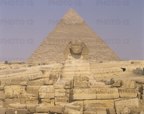 Giza, Cairo Area, Egypt. Pyramid and the Sphinx. Egypt Egyptian Africa African Cairo Giza Pyramids Pyramid Sphinx Desert Ancient Sand History Culture Old Stone Yellow Statue Sculpture Blue Cultural Cultures Destination Destinations History Historic Middle East North Africa