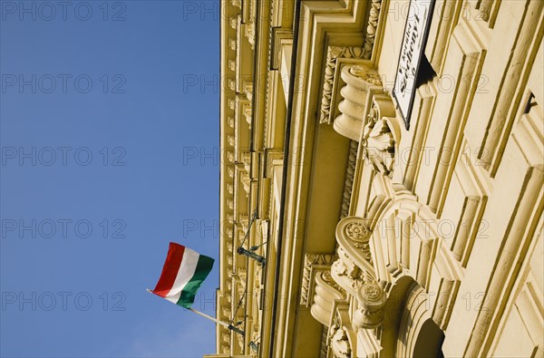 Budapest, Pest County, Hungary. Renovated facade on Pest bank of Danube with Hungarian flag. Hungary Hungarian Europe European East Eastern Buda Pest Budapest City Architecture Flag Tricolor Tricolour Green Red Red Detail Blue Sky Destination Destinations Eastern Europe