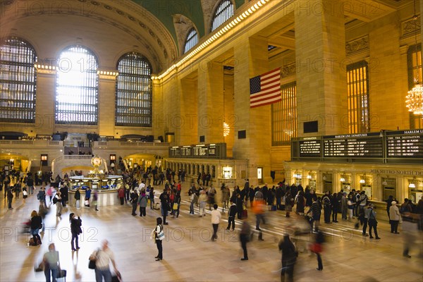 USA, New York, New York City, Manhattan  Grand Central Terminal railway station with people walking in the Main Concourse and passengers buying tickets.