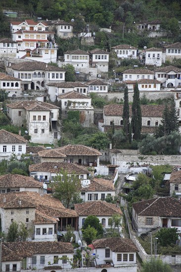 Albania, Berat, Traditional white painted Ottoman buildings with tiled rooftops on hillside in the old town.
