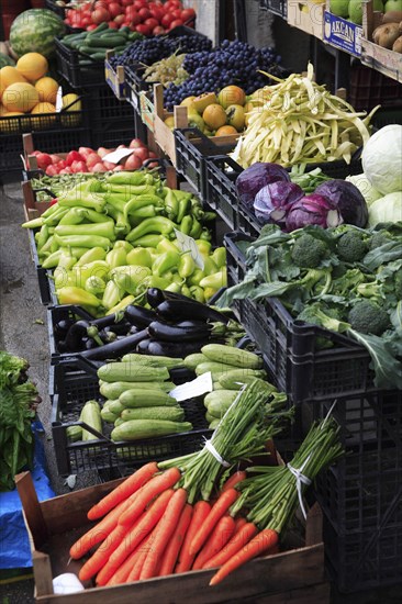 Albania, Tirane, Tirana, Grocers fruit and vegetable shop front in the Avni Rustemi market with display including grapes  cabbage  peppers  aubergine and carrots.