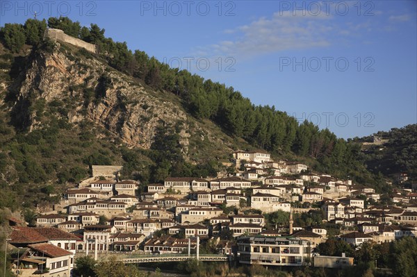 Albania, Berat, Traditional Ottoman buildings on hillside above footbridge over the River Osum.