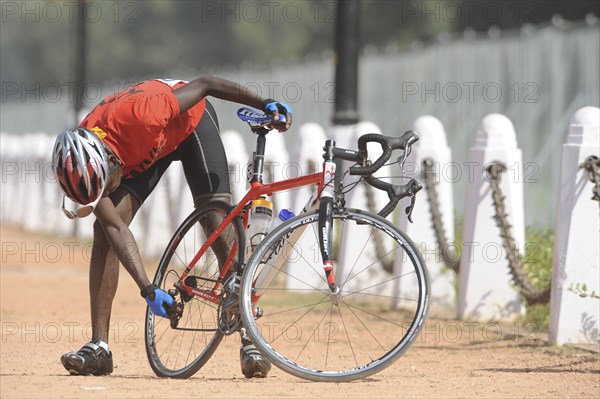 India, Delhi, 2010 Commonwealth games  Road cycling event competitor checking gears on his bike.