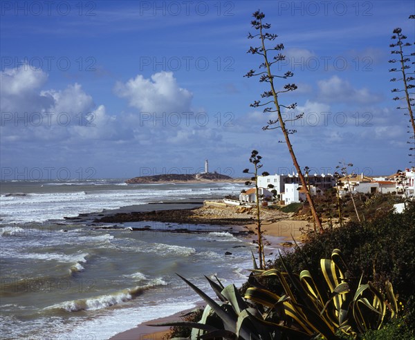 Spain, Andalucia, Cadiz, Cape Trafalgar and Los Canos de Meca village apartments overlooking beach with surf breaking on the sand.