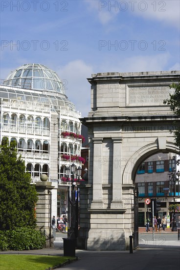 Ireland, County Dublin, Dublin City, Saint Stephens Green shopping arcade and Fusiliers Arch entrance into the park with people.